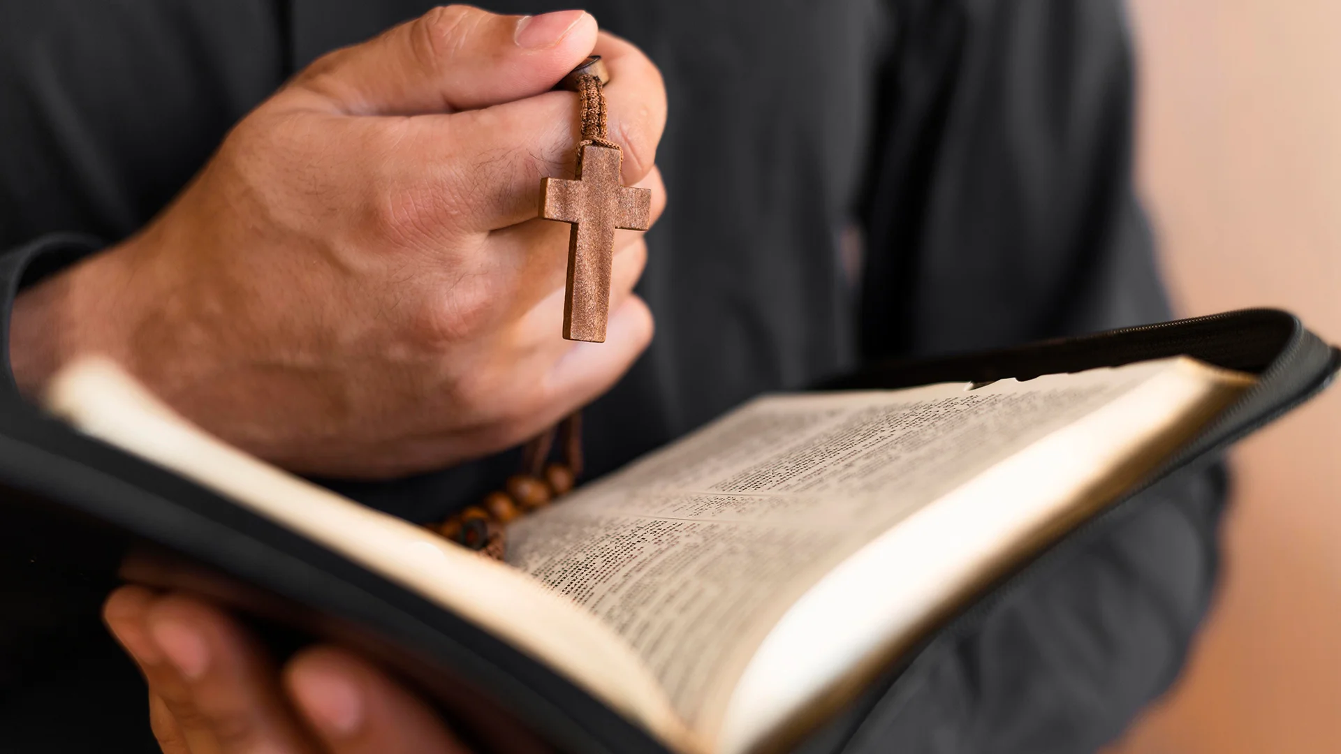 holding holy book and rosary