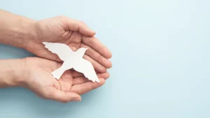 Hands holding paper bird cutout